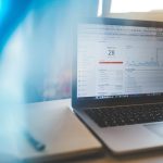 Laptop montrant graphique avec 28, stylo et cahier sur table